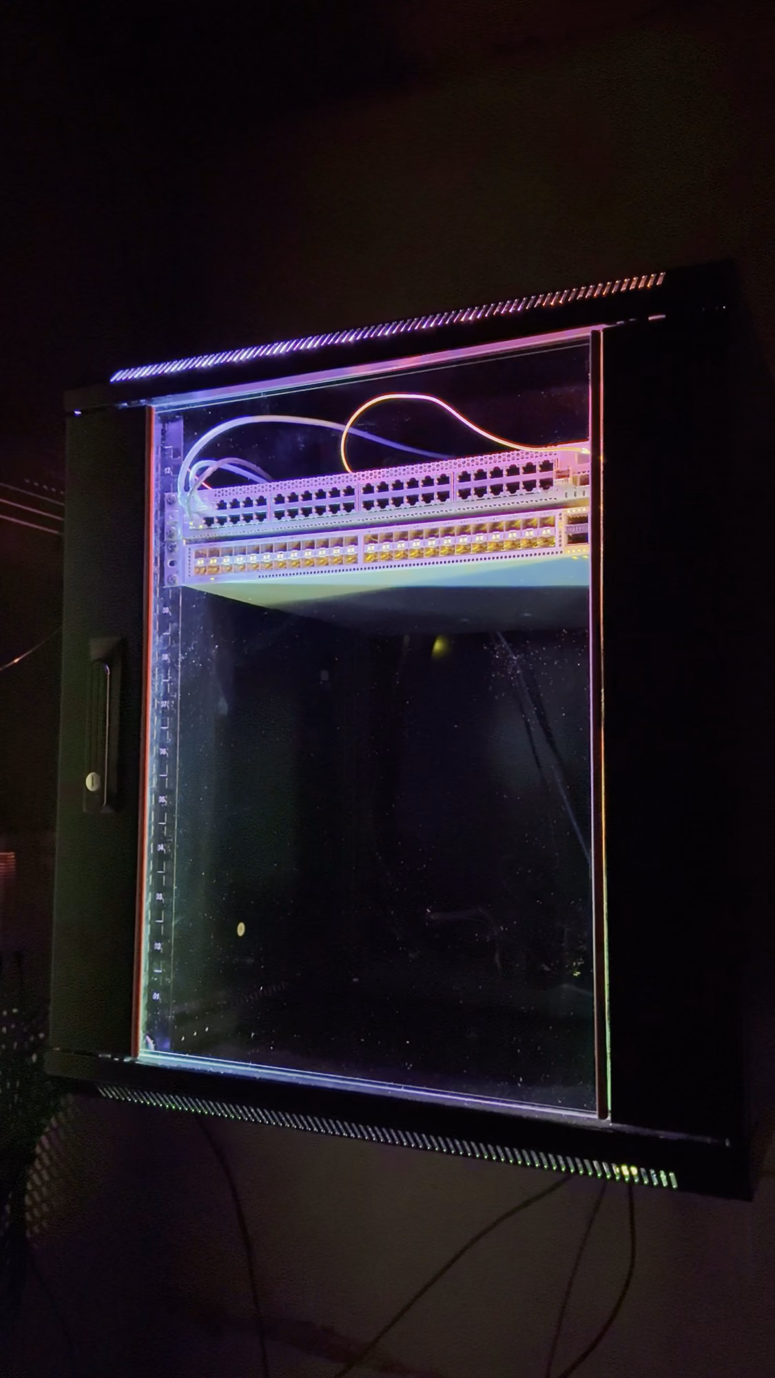 Wall-mounted 12U rack with addressable RGB lighting, patch panel and switch up top